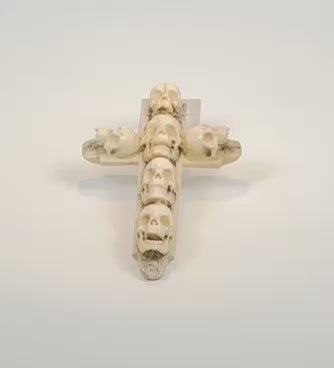 Video showing the carved details and aged surfaces of an antique six-skull bone memento mori cross