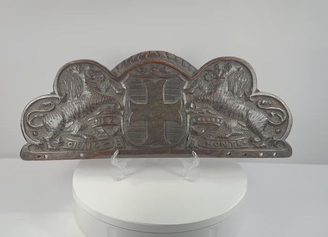 Rotating view of an antique hand-carved oak Bentinck heraldic pediment featuring a cross moline, paired lions, and the motto Craignez Honte
