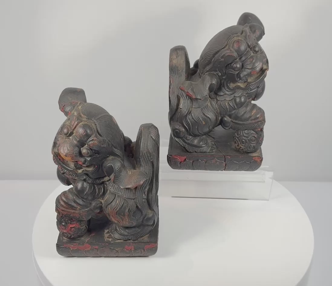 Antique Chinese Qing Dynasty guardian lion pair rotating to show the mirrored Foo dog forms, carved brocade balls, stylized manes, raised tails, aged lacquer and polychrome decoration.