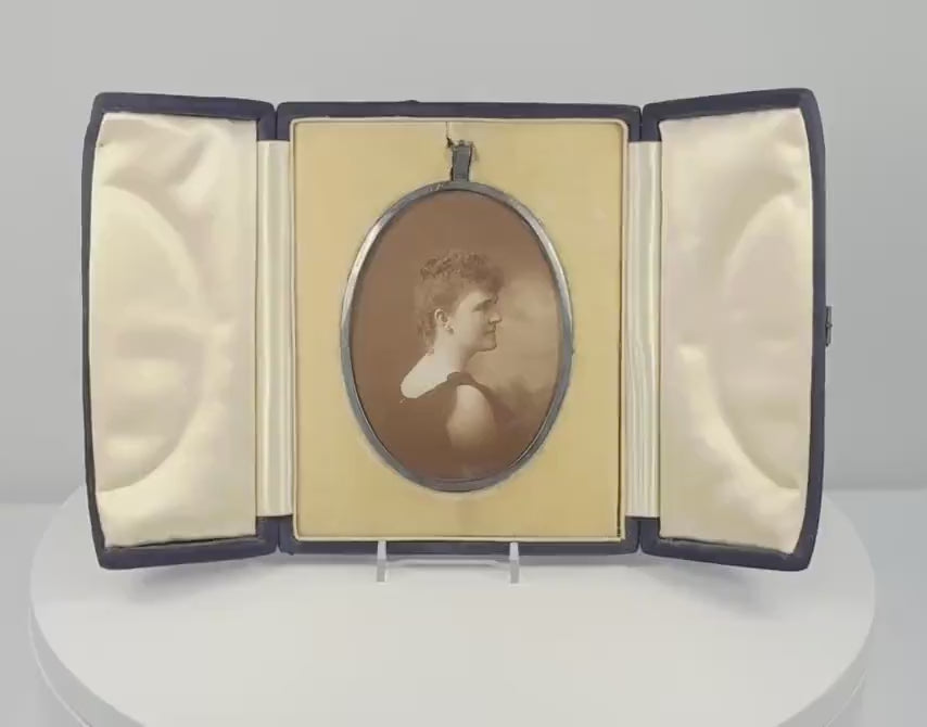 360-degree rotating video of a late Victorian oval sepia portrait of a woman in an elaborate upswept hairstyle, displayed in a black velvet-covered folding presentation case, circa 1895–1915.