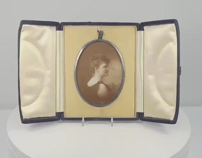 360-degree rotating video of a late Victorian oval sepia portrait of a woman in an elaborate upswept hairstyle, displayed in a black velvet-covered folding presentation case, circa 1895–1915.