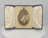 360-degree rotating video of a late Victorian oval sepia portrait of a woman in an elaborate upswept hairstyle, displayed in a black velvet-covered folding presentation case, circa 1895–1915.