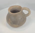 Rotating view of an authentic Pre-Columbian Casas Grandes pottery mug from northern Mexico, highlighting its hand-formed earthenware construction, globular body, flared rim, curved strap handle, archaeological patina, and centuries-old Paquimé craftsmanship.
