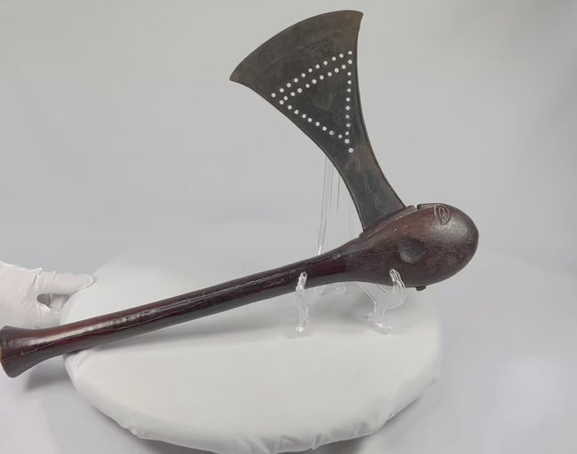 360-degree view of a Luba prestige axe showing punchworked iron blade, carved eye-form pommel, and ceremonial patina