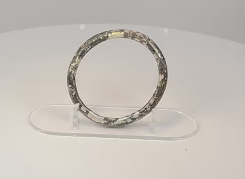360-degree view of ancient Roman dark glass bracelet with iridescent weathering, mineral deposits, and archaeological patina
