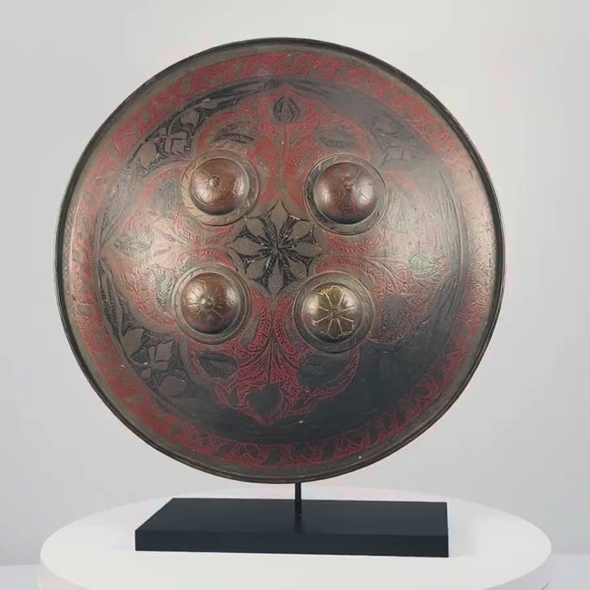Video of Indo-Persian Dhal shield with red and black lacquer, damascened foliate motifs, four raised bosses, and interior grips