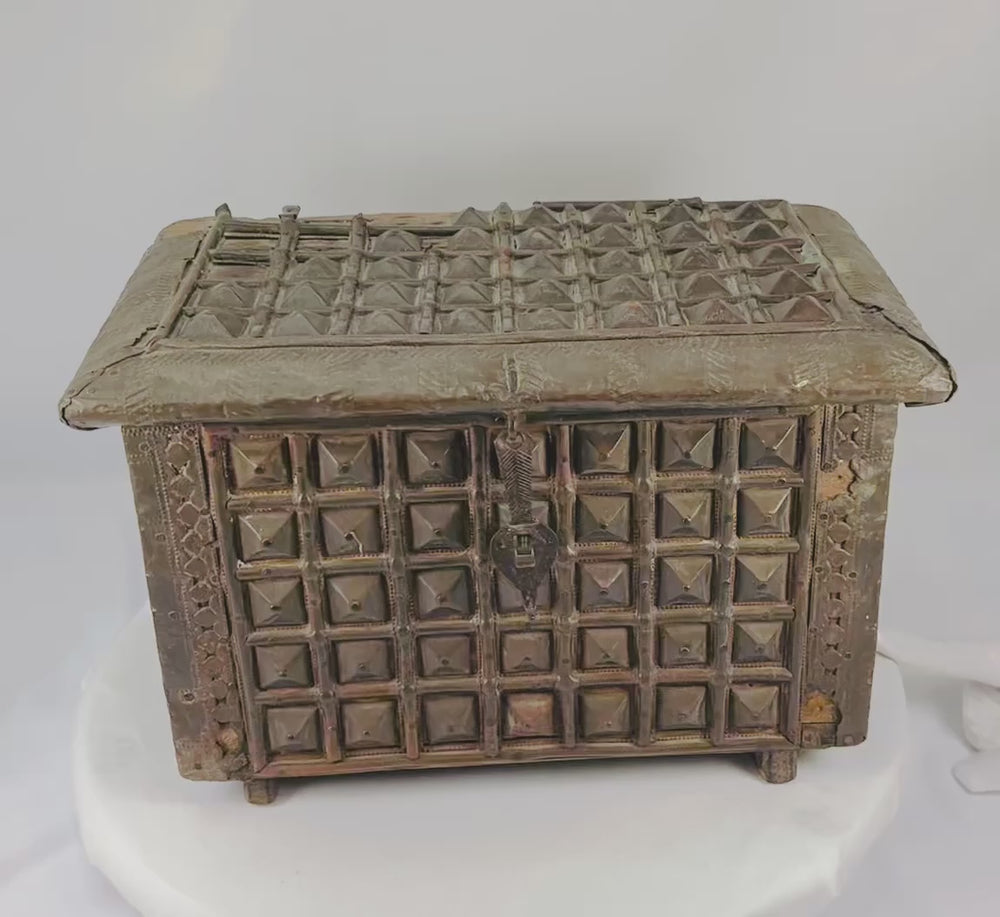 Late 19th-century Indian lidded box made of hardwood with brass cladding, featuring embossed geometric and pyramid-like designs. Original lock and latch intact. Combines traditional Indian craftsmanship, functional storage, and decorative elegance.