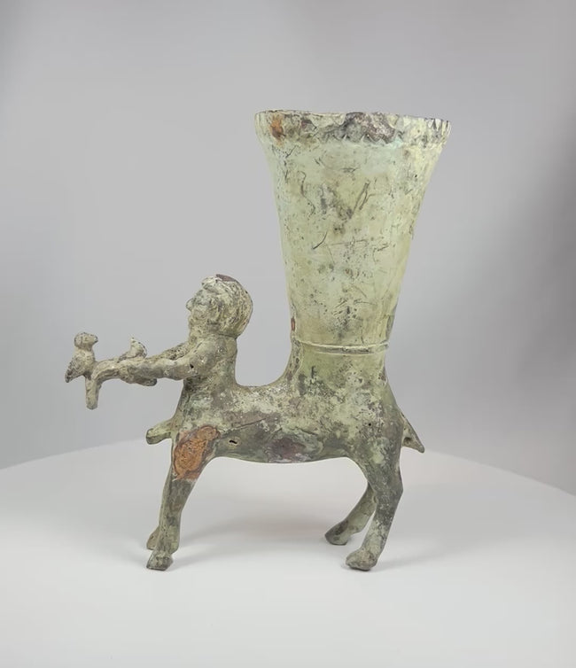 360 degree rotating view of antique bronze rhyton vessel with centaur figure holding goat showing detailed patina and sculptural form from all angles