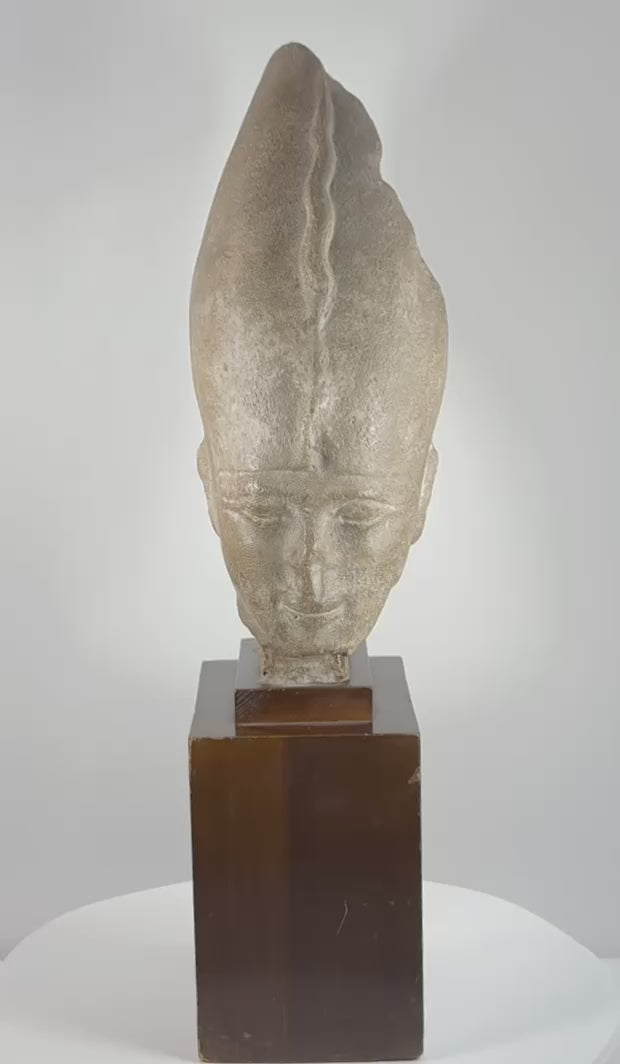 Rotating view of a 20th-century Egyptian Revival pharaoh head wearing the White Crown, displayed on a tiered dark hardwood stand