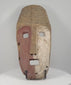 360-degree rotating video of a Sepik River tribal ritual mask from Papua New Guinea, circa 1900–1940, featuring hand-carved hardwood, a distinctive elongated face, split red and white pigmentation, geometric forehead carvings, and rectangular mouth opening. Displayed on a black museum-style stand.