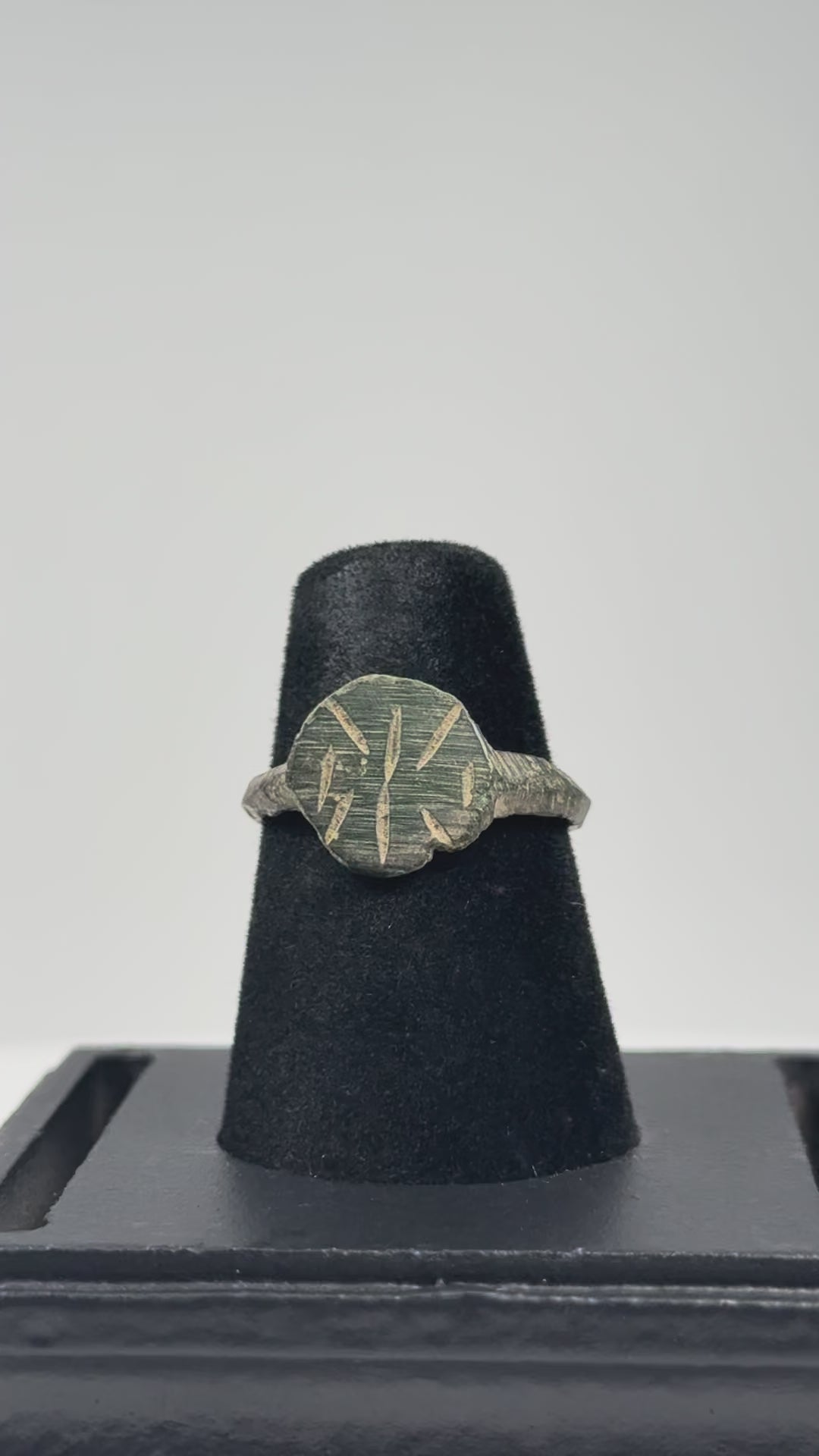 Video showing an Early Byzantine bronze finger ring with radiate geometric bezel, incised hoop decoration, complete band, and archaeological patina from multiple angles.