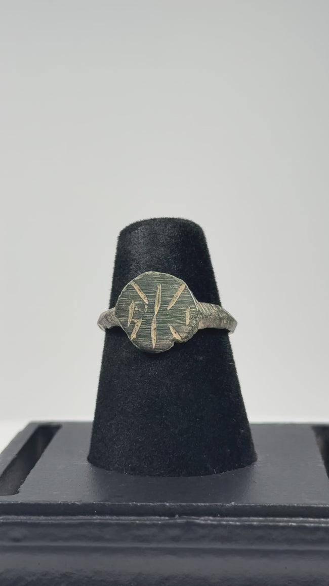 Video showing an Early Byzantine bronze finger ring with radiate geometric bezel, incised hoop decoration, complete band, and archaeological patina from multiple angles.