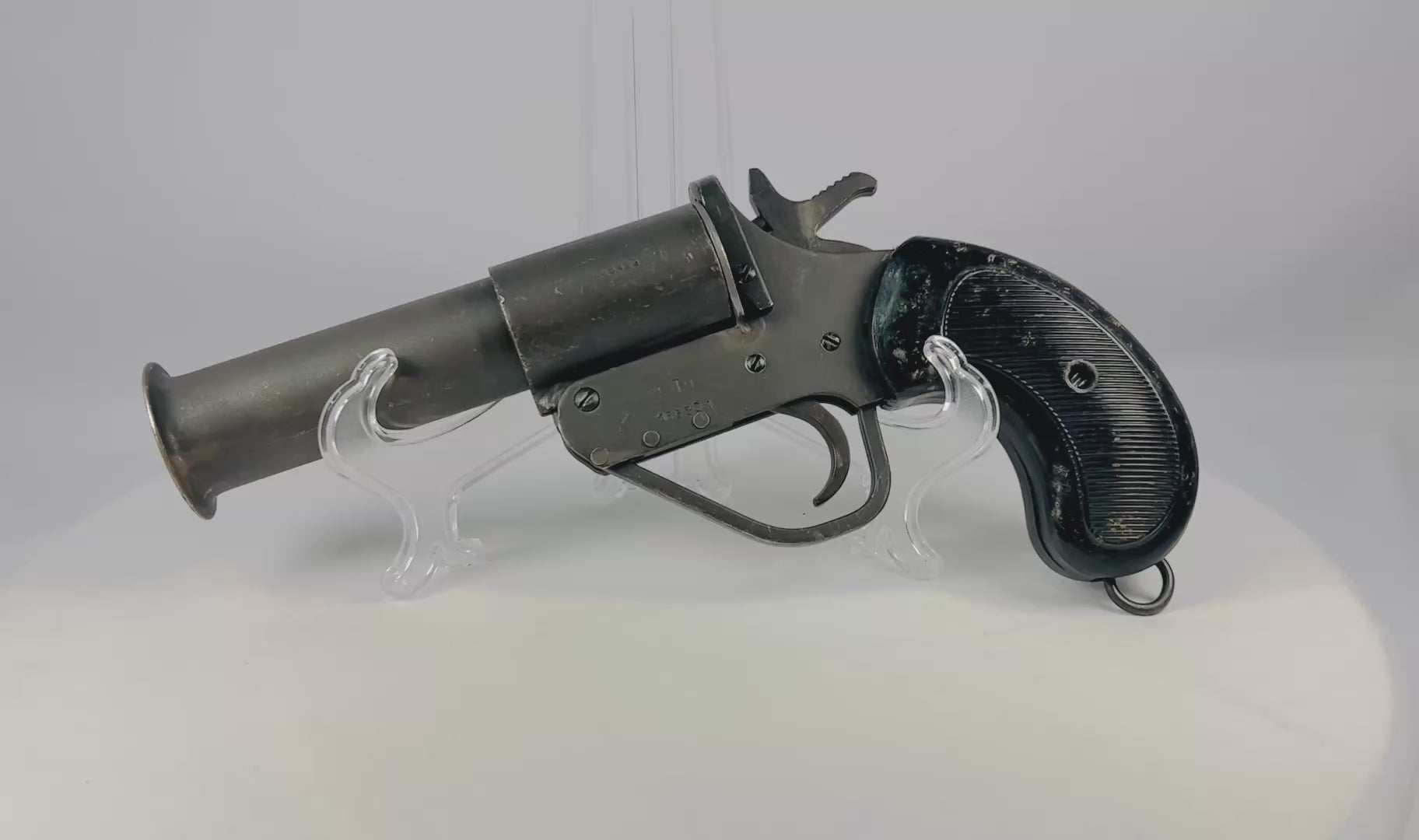 World War II Webley Model No. 1 MK. V flare gun, stamped steel construction, 1-inch bore with flared bell muzzle, original checkered black plastic/bakelite grips, lanyard ring, serial #148583, issued to British, Canadian, and Allied forces, circa 1939–1945