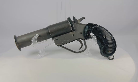 World War II Webley Model No. 1 MK. V flare gun, stamped steel construction, 1-inch bore with flared bell muzzle, original checkered black plastic/bakelite grips, lanyard ring, serial #148583, issued to British, Canadian, and Allied forces, circa 1939–1945
