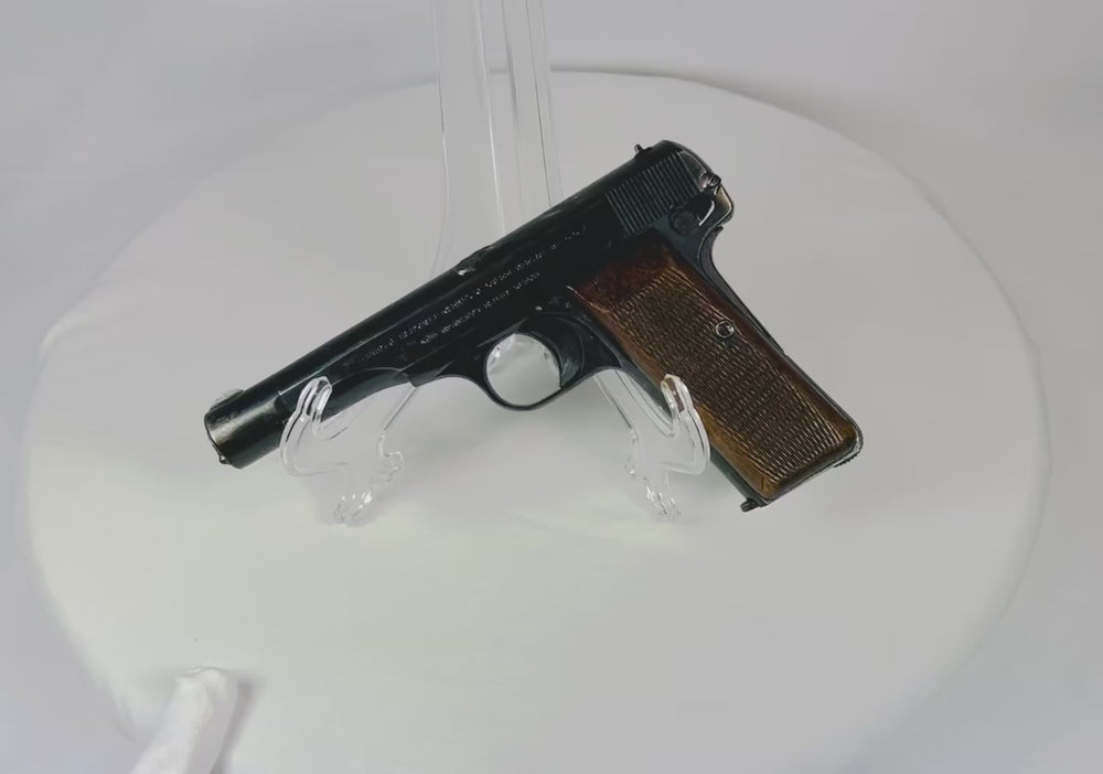 Rotating view of a deactivated Belgian Browning Fabrique Nationale Model 1922 pistol with walnut grips and visible Nazi eagle markings, displayed on a white background.