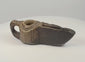 Rotating 360-degree video of an early Islamic carved stone oil lamp, showing its geometric decoration, wick spout, stone construction, and aged patina.