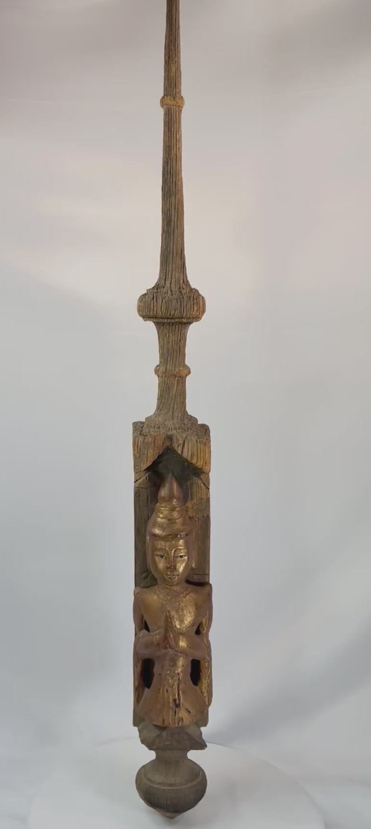 Monumental 45-inch Burmese temple finial, late 19th–early 20th century, carved hardwood with gilded Buddha in Anjali Mudra and spire form, retaining aged patina.