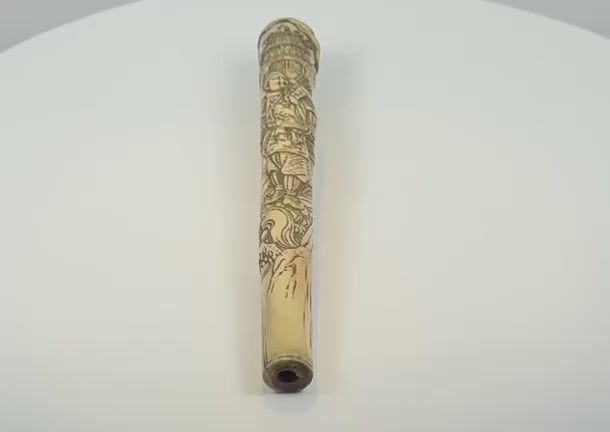 Video showcasing a Japanese Meiji-period carved bone handle or sword fitting with samurai imagery, landscape details, darkened engraving and an open attachment socket, circa 1870–1910