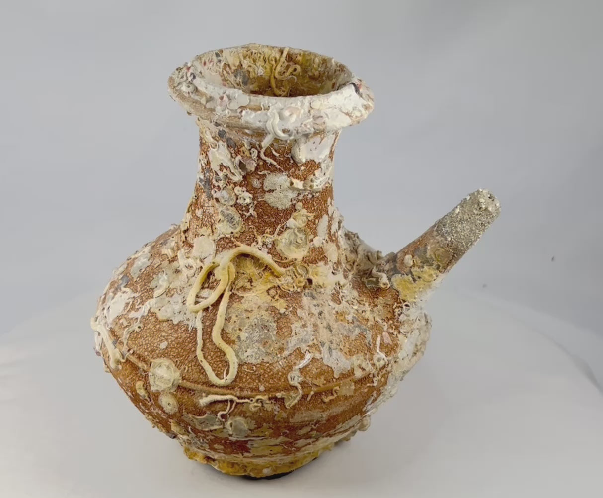Song Dynasty terracotta wine pot recovered from Balabac Island, Philippines, heavily encrusted with marine deposits, featuring wide rounded body and slender spout, maritime shipwreck artifact