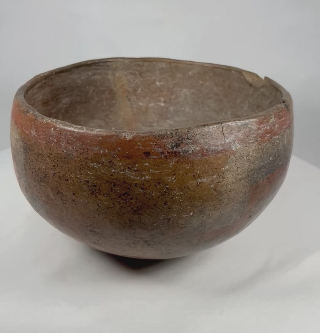 Rotating view of an ancient Pre-Columbian West Mexican painted terracotta bowl, showing rounded profile, geometric pigment decoration, aged surface, and archaeological patina.