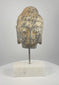 Video showing multiple angles of an 18th–19th century Southeast Asian carved stone Buddha head with curled hair, traces of pigment and a modern marble display base