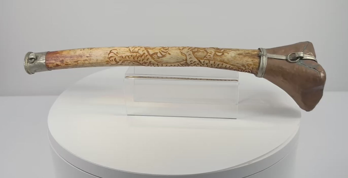 Rotating presentation of antique Tibetan Buddhist kangling human femur bone ritual trumpet with carved dragon motifs and metal fittings