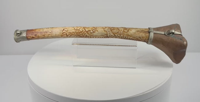 Rotating presentation of antique Tibetan Buddhist kangling human femur bone ritual trumpet with carved dragon motifs and metal fittings