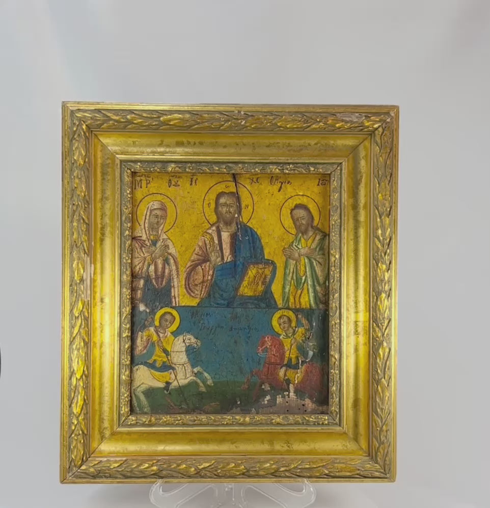 Greek Orthodox icon painting with Christ Pantocrator, Virgin Mary, and St. John the Baptist in the upper register, St. George slaying the dragon, and St. Demetrius on horseback in the lower register, painted in tempera with gold background, framed in ornate gilt foliate frame, photographed on a white background.