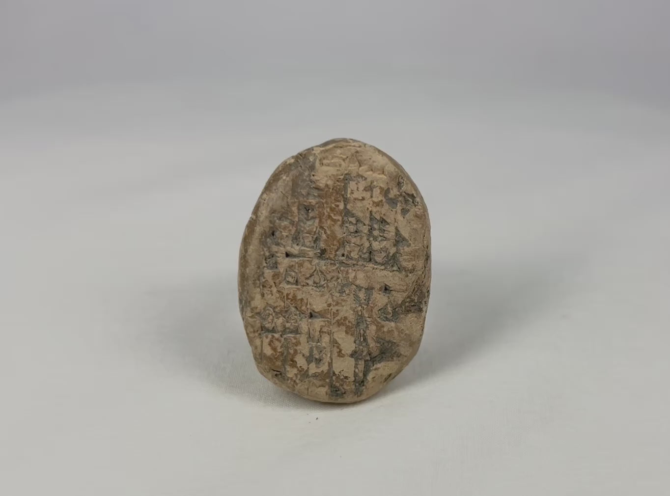 Old Babylonian baked clay cuneiform tablet, 1900–1600 BCE Mesopotamia, bi-faced lenticular school tablet with student practice inscriptions, earthen patina and mineral accretions