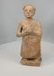 Rotating view of primitive terracotta standing male figure with textured surface and stylized features
