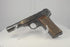 Video of a deactivated WWII FN Browning Model 1922 on a clear display stand, showing worn blued steel and checkered walnut grips.