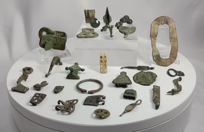 360-degree rotating view of a collection of ancient Roman bronze artifacts including belt fittings, harness mounts, buckles, and decorative metal fragments from the Roman Empire (1st–4th century CE)