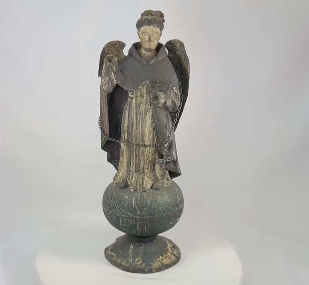 Antique Colonial Latin American polychrome wooden angel or saint figure, 18th–19th century, standing on orb base, gilded wings, remnants of original painted surface, later added sterling silver chain and cross marked 'Sterling, Mexico', traditional folk-religious craftsmanship