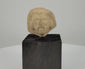 360-degree rotating video of an ancient Near Eastern terracotta male head fragment featuring a detailed beard, prominent facial features, deeply carved eyes, and a distinctive sculpted hairstyle. Dating to circa 1st millennium BCE, mounted on a black display stand.