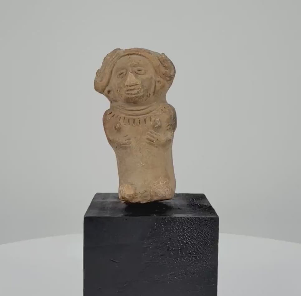360-degree rotating video of an ancient seated female terracotta figurine from Veracruz, Mexico, circa 600–900 CE, featuring an elaborate headdress, detailed facial features, decorative necklace, and sculpted hands resting on the torso. A Pre-Columbian artifact with natural earthen patina.