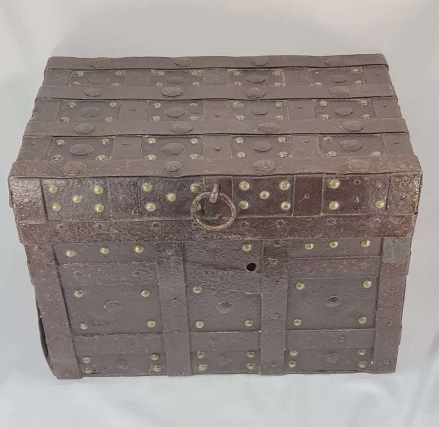 360-degree rotating view of a heavy wrought-iron Iberian strongbox dated 1840, showing studded strapwork exterior, patina, missing side handle, interior brass plaque, green paint remnants, and functioning lid with chain.
