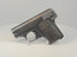 Deactivated FN Browning Model 1906 pocket pistol on a display stand, showing worn blued steel and checkered FN-monogram grips.