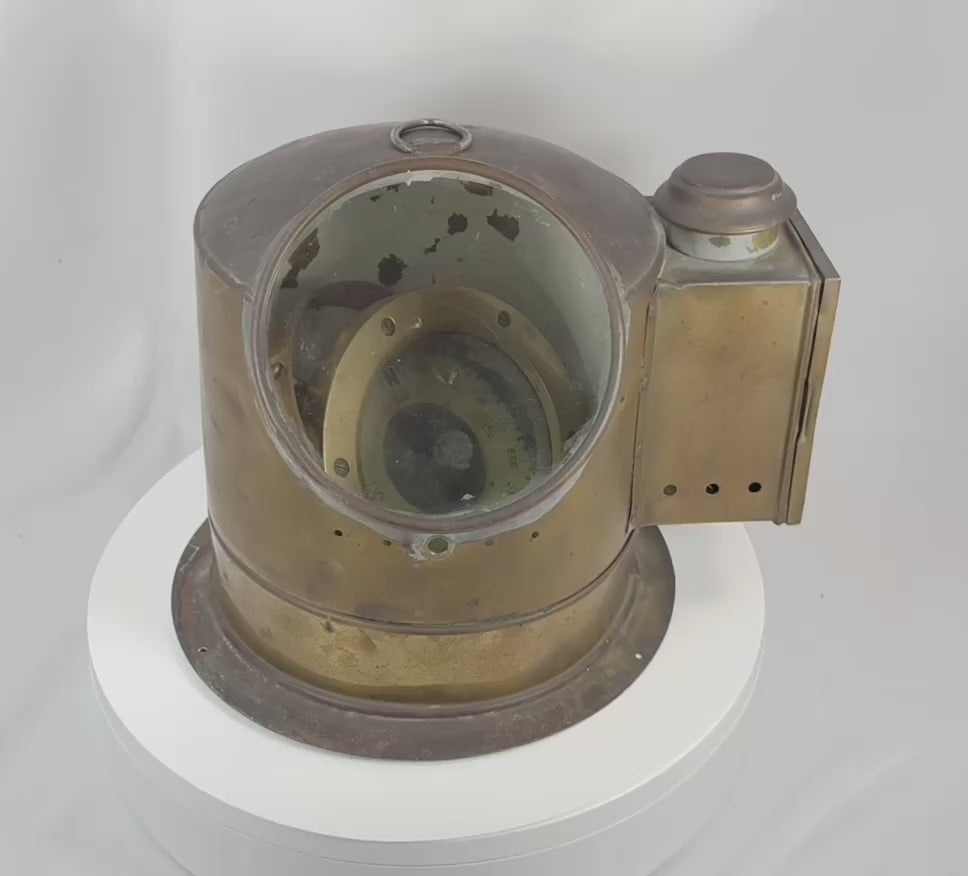 360-degree view of an antique brass maritime binnacle compass featuring a helmet-form body, glass viewing window, gimbaled liquid compass, and aged nautical patina