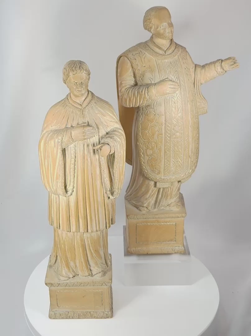 360-degree rotating view of a pair of antique hand-carved European religious wooden sculptures depicting saintly and ecclesiastical figures. The carvings feature detailed vestments, expressive facial features, integral pedestal bases, and a rich aged patina characteristic of 18th–19th century devotional art.