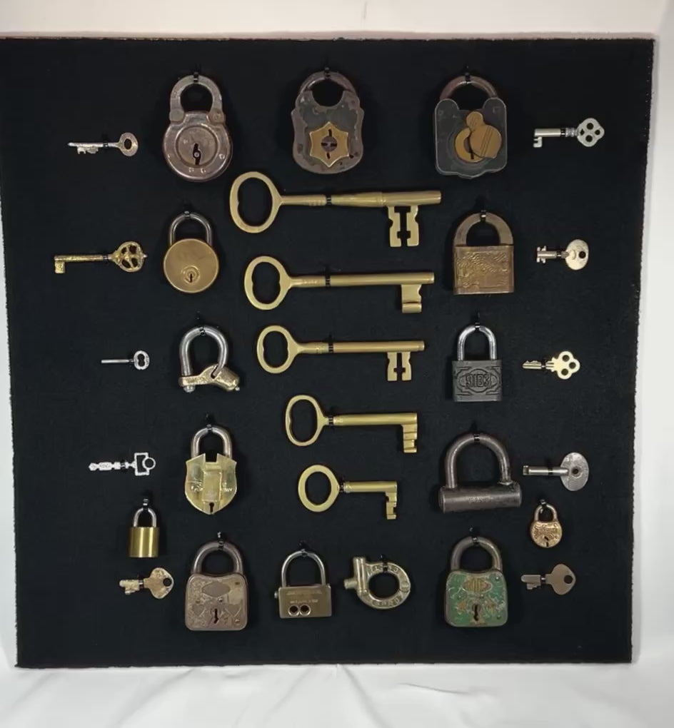 Close-up video of antique lock and key collection showing detailed zoom of each padlock, skeleton key, and full framed display