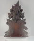 Antique Black Forest-style carved wood furniture crest shown in detail, highlighting the fruit basket, foliage, pierced carving, aged patina, mounting points and historic repairs.
