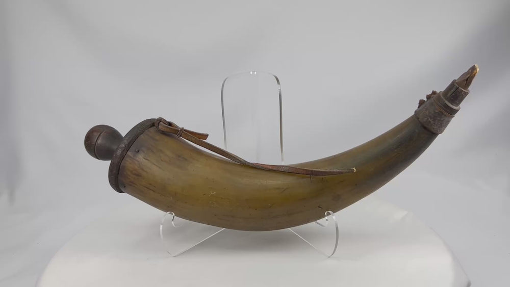 360-degree rotating view of an antique black powder horn from the late 1700s to early 1800s, showing polished horn surface, wooden base plug, strap remnants, and aged patina.