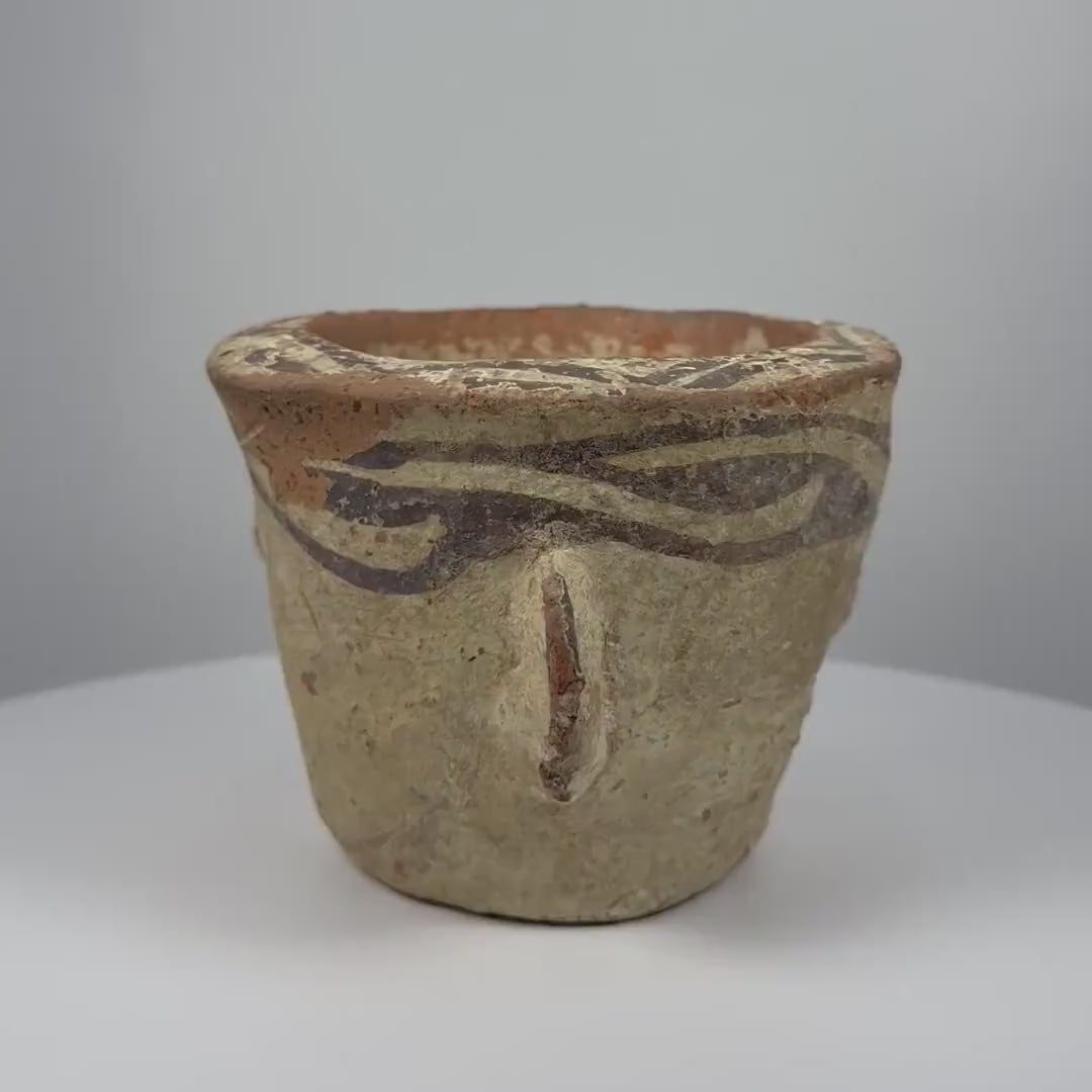 Ancient Afghan terracotta mortar dating to the 12th century CE during the Islamic Golden Age, featuring decorative black slip motifs around the rim, projecting side handles, a rounded grinding compartment, natural interior abrasions, warm earthen patina, and traditional medieval Islamic pottery craftsmanship.