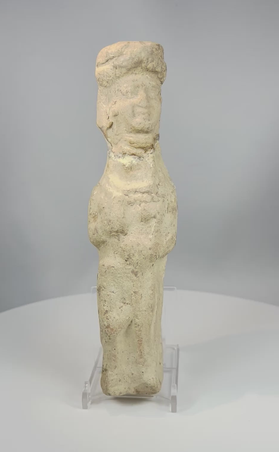 Video showcasing ancient Mesopotamian terracotta female figurine with folded arms mineral patina and stylized form from multiple angles