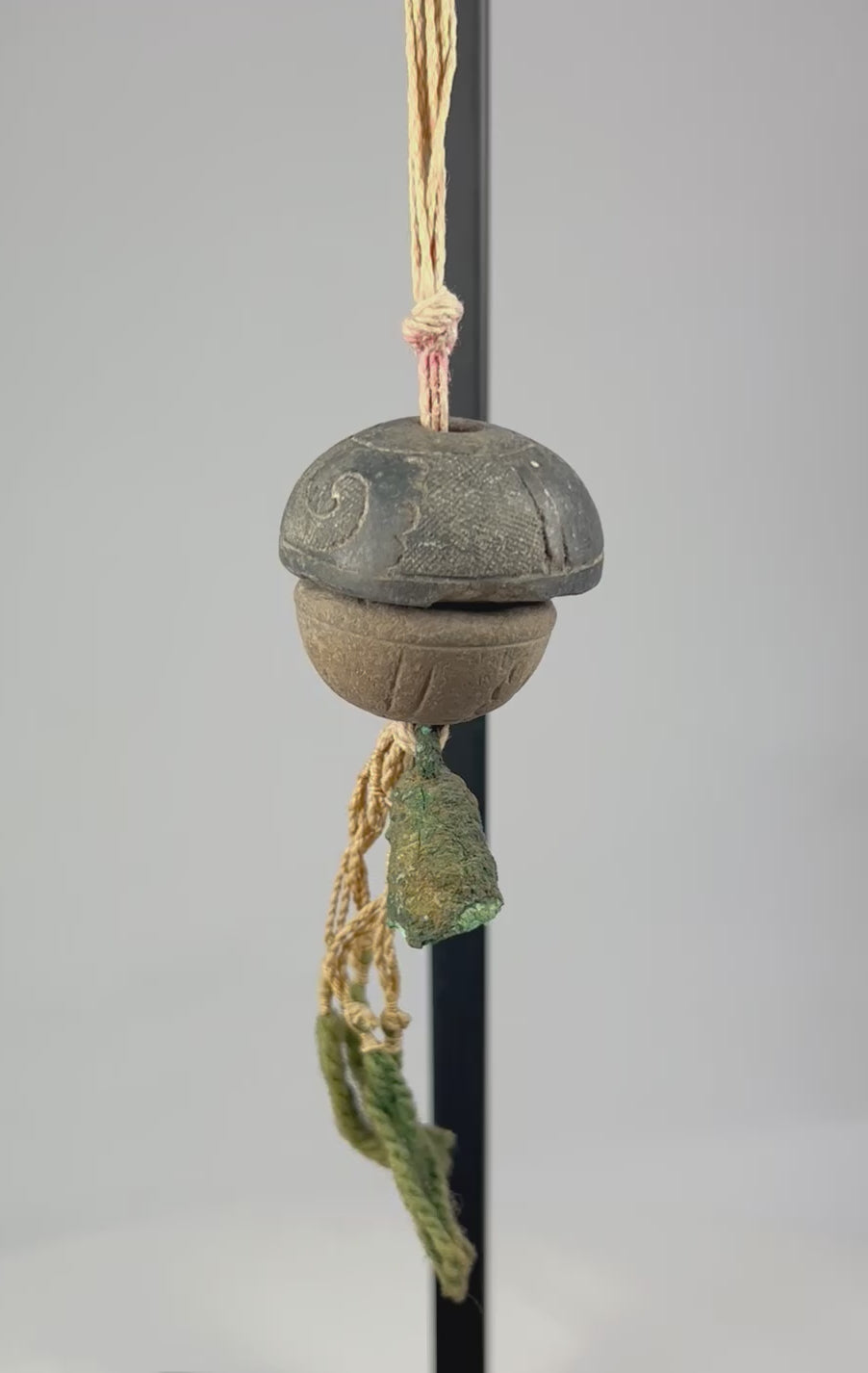 360-degree rotating view of an ancient bronze ritual bell pendant with original fiber cord, verdigris patina, and intact clapper