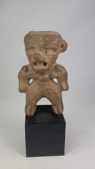 Ancient Pre-Columbian terracotta standing figure from West Mexico (Nayarit/Colima/Jalisco), circa 300 BCE–500 CE, with stylized head, pierced ears, and wide stance, mounted on a black display base, photographed on a white background