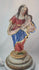 Spanish Colonial Madonna and Child statue, circa 1780–1820, hand-carved wood with original polychrome and gilding. Virgin in red and blue robes with gilt highlights holds infant Christ with golden orb. Mounted on original socle with craquelure and age wear.