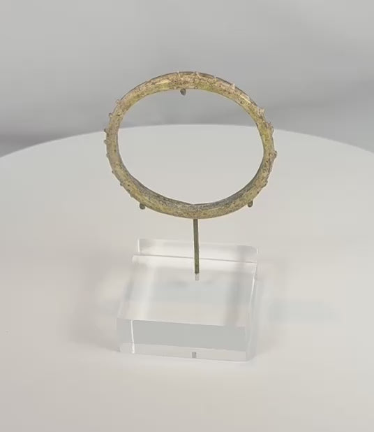 Rotating view of an ancient Roman glass bracelet with applied nodular decoration, showcasing iridescence, archaeological weathering, and complete circular form from the Roman Imperial Period.