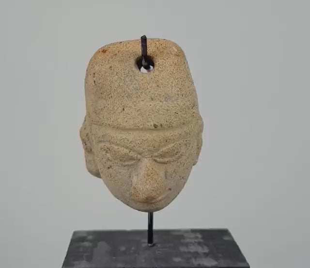 360-degree rotating video of an ancient Mesoamerican terracotta clay amulet head attributed to the Colima or Nayarit region of West Mexico, circa 300 BCE–300 CE. Pre-Columbian artifact showcasing traditional sculptural craftsmanship and age-related surface wear.