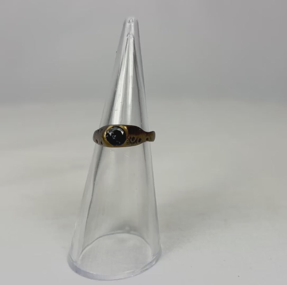 360-degree view of an ancient brass ring rotating on a clear display cone